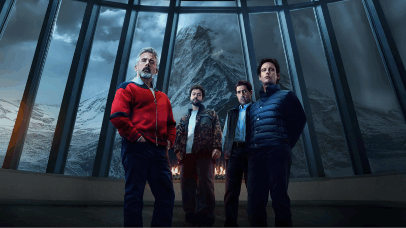 Corte da capa do filme “Mountainhead”, dirigido pelo diretor Jesse Armstrong. Na foto, quatro homens estão em frente a uma grande janela panorâmica que revela uma montanha coberta de neve. Eles usam roupas modernas e são iluminados pelo fogo da lareira atrás deles. As expressões sérias passam uma atmosfera de suspense.