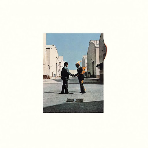 Capa do álbum Wish You Were Here do Pink Floyd. Na capa, ambientada no estacionamento dos estúdios da Warner Bros, um pátio de cimento com galpões bege nas laterais, dois homens de terno apertam as mãos enquanto um deles está em chamas.