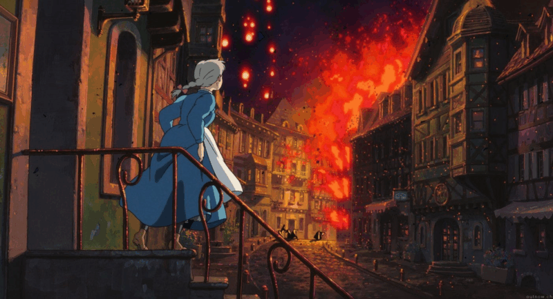 Cena da animação O Castelo Animado, do Studio Ghibli. A imagem mostra Sophie, uma jovem de cabelos brancos presos em uma trança, vestindo um longo azul com avental branco. Ela está de pé em uma escadaria externa, olhando para uma rua de uma cidade com arquitetura europeia. O céu e os prédios ao fim da rua estão dramaticamente pegando fogo e iluminados em tons de vermelho e laranja.