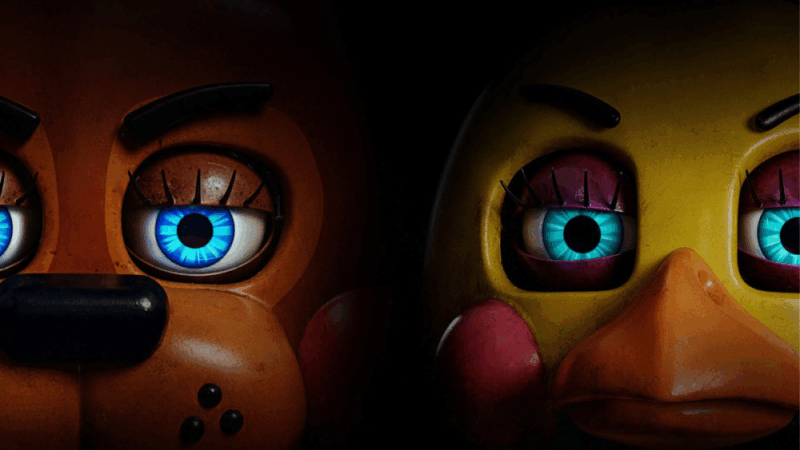 Cena de Five Nights at Freddy’s 2. A cena mostra dois animatrônicos, Freddy Fazbear e Chica, retratados lado a lado em um fundo escuro. Freddy, à esquerda, apresenta um tom marrom-alaranjado, com um olho grande azul brilhante, com cílios compridos e sobrancelhas escuras. O focinho é largo e mostra detalhes, com pequenas manchas escuras e um nariz preto. Chica, à direita, é amarela vibrante, com um bico laranja e bochechas rosa. Ela compartilha um estilo de olho similar, com um olho brilhante e azul esverdeado, com cílios rosa e sobrancelhas. A composição é focada nos rostos, com uma iluminação dramática que realça os olhos e cria um contraste marcante com o fundo negro, aumentando o suspense. A imagem tem um estilo realista e detalhado, remetendo ao design característico da franquia Five Nights at Freddy's.