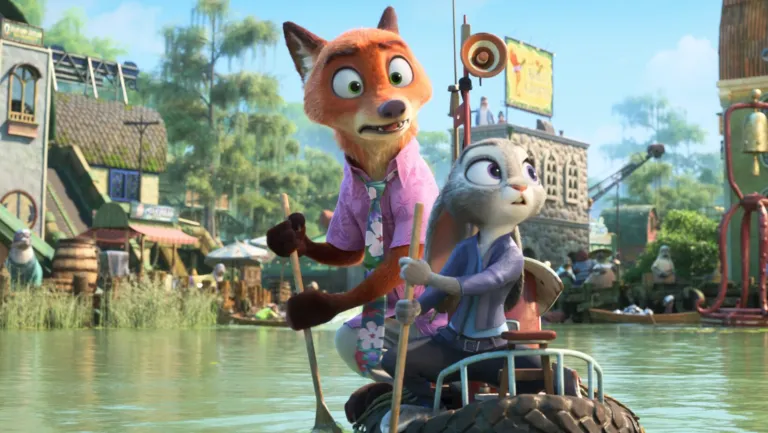 Cena de Zootopia 2. A cena mostra Nick Wilde e Judy Hopps remando juntos em um barco, ambos surpresos e em alerta enquanto atravessam um rio pitoresco. O plano médio destaca a parceria dos dois, que seguram os remos lado a lado e reagem a algo inesperado no ambiente. Nick, com sua pelagem laranja e camisa rosa florida, exibe preocupação, enquanto Judy, com colete azul e olhar atento, parece assustada. A arte digital segue o estilo vibrante da Disney, com texturas detalhadas nos personagens e na água. O cenário de pântano ou rio, cercado por vegetação e construções charmosas, iluminado por luz natural, cria um clima de aventura e antecipação.