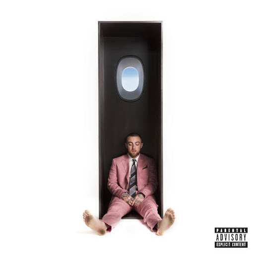 Capa do álbum Swimming (2018) do rapper Mac Miller. A imagem é minimalista, com fundo totalmente branco. No centro, Mac Miller está sentado descalço dentro de um compartimento vertical e retangular de cor preta, semelhante ao interior de uma cabine de avião. Acima de sua cabeça, há uma janela de avião, por onde se vê um céu azul claro. Mac Miller veste um terno rosa claro com uma camisa branca e uma gravata estampada com tons escuros e coloridos. No canto inferior direito da imagem há o selo de “Parental Advisory Explicit Content”, indicando conteúdo explícito no álbum.