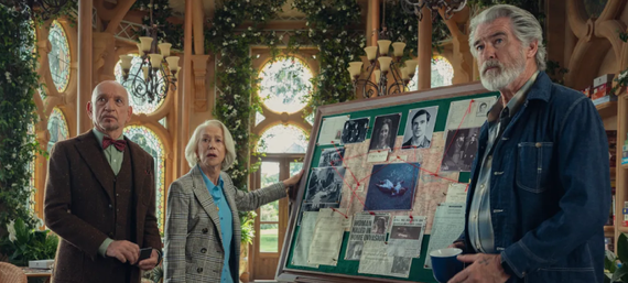 Na imagem, está Elizabeth,uma mulher branca de cabelos brancos soltos e curtos e vestindo uma blusa azul e um blazer xadrez; Ibrahim, homem de ascendência indiana, careca, que veste um colete e blazer marrom e uma gravata borboleta magenta e Ron, um homem branco de cabelos brancos e com camisa xadrez azul e branca e uma jaqueta jeans. Os três estão olhando para frente e parecem surpresos. O cenário é composto por uma sala ampla, com janelas grandes e cobertas por plantas ornamentais. Além disso, há um quadro estilo detetive, com fotografias, documentos e fios vermelhos conectando as imagens.