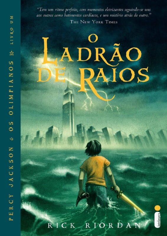 A imagem é a capa do livro O Ladrão de Raios, e mostra Percy de costas, caminhando pelo mar agitado em direção a uma grande cidade ao fundo. Ele segura uma espada dourada na mão direita. À frente dele, há uma cidade grande com prédios altos, parcialmente coberta por névoa. O céu está escuro e nublado, e um raio cai próximo aos prédios, indicando uma tempestade. As cores predominantes são verde, azul e tons escuros, transmitindo uma sensação de perigo, aventura e mistério, que combina com a história do livro.