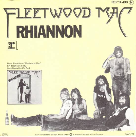 Descrição: Capa com fundo amarelo. O nome da banda e o título “Rhiannon” aparecem em destaque. À direita, há uma foto em preto e branco dos cinco integrantes sentados de forma descontraída, com visual típico dos anos 1970. À esquerda, uma imagem menor do álbum e informações técnicas do disco.