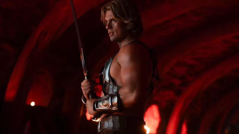No centro, He Man, herói loiro e musculoso, segurando uma grande espada apontada para cima sob um relâmpago azul. Ao redor dele aparecem guerreiros, criaturas fantásticas, Skeletor, um vilão encapuzado com aparência sombria e personagens com armaduras futuristas e armas. O fundo mistura tons quentes de fogo e destruição à esquerda com tons frios e mágicos à direita, além de um castelo ao fundo e exércitos posicionados dos dois lados, criando uma atmosfera épica de batalha entre forças do bem e do mal.
