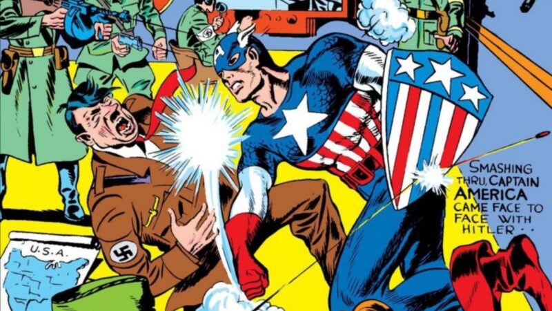Capa da primeira edição do quadrinho Capitão AméricaNa imagem, o personagem Capitão América dá um soco com a mão direita no rosto de Hitler, que cai em gritos de dor. O herói utiliza uma fantasia com as cores da bandeira dos Estados Unidos (vermelho e azul), com uma estrela branca no peito e listras brancas e vermelhas no abdômen. Utiliza botas e luvas vermelhas, o antebraço é branco e o resto do uniforme azul. O pescoço está à mostra e os olhos e os cabelos estão cobertos por uma máscara azul com um A escrito na testa e asas de anjo nos cantos. Na mão esquerda, ele usa um escudo em formato de noz (triangular) com as mesmas cores da bandeira, listras e três estrelas no topo. O escudo ricocheteia uma bala. Capitão América é um homem branco. Ao fundo, há soldados de Hitler empunhando armas e atirando. Hitler é um homem branco, de cabelos escuros e bigode. Ele usa um terno marrom e no braço direito usa a suástica nazista.