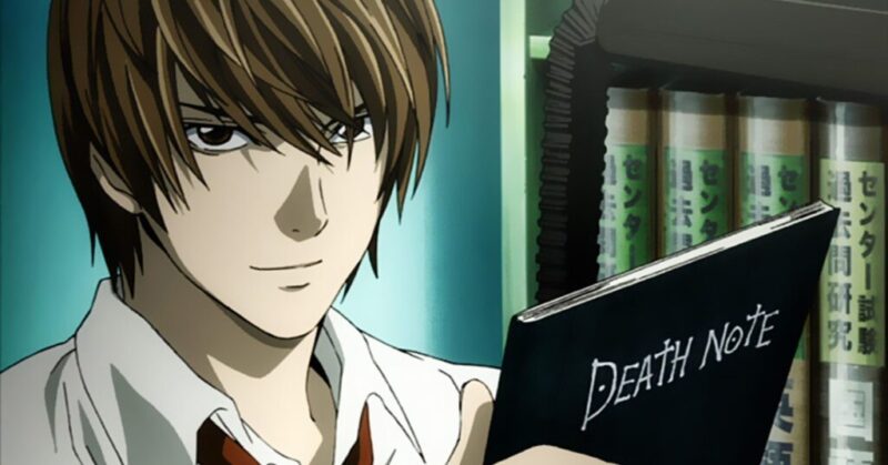 Cena do anime Death Note. A imagem mostra um homem próximo de uma estante de livros. Ao lado esquerdo, está um homem branco de cabelos e olhos castanhos. Ele olha diretamente para frente com uma expressão séria e um sorriso malicioso. Ele usa uma camisa branca com gola alta e uma gravata vermelha. Ele segura um caderno preto em uma das mãos, o levando para perto de seu rosto. No caderno, vemos as palavras “Death Note”. Ao fundo, vemos uma parede azul claro e uma estante verde com livros da mesma cor, seus títulos estão em japonês. 